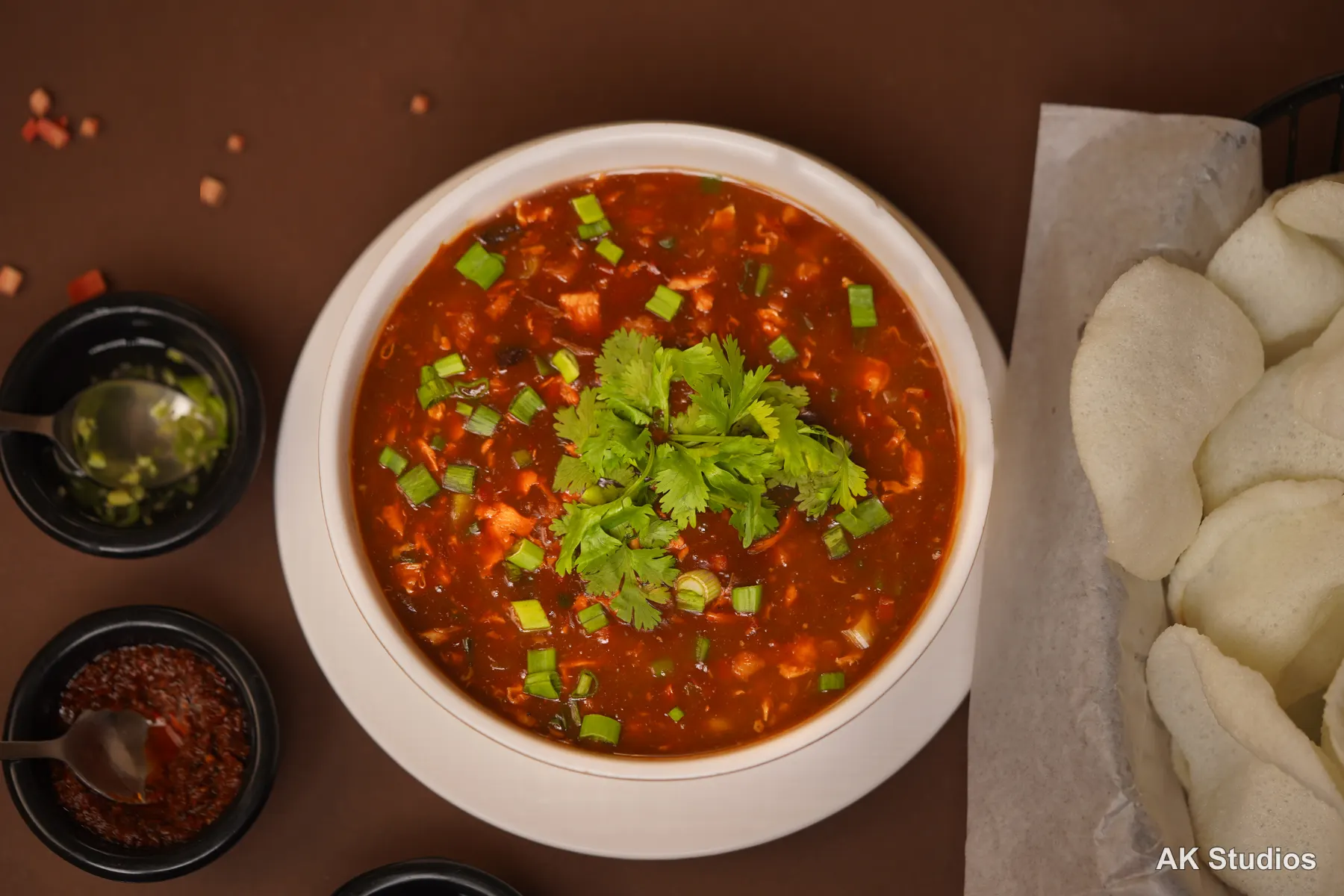 Saltish restaurant hot and sour soup with prawn crackers, top-down food photography
