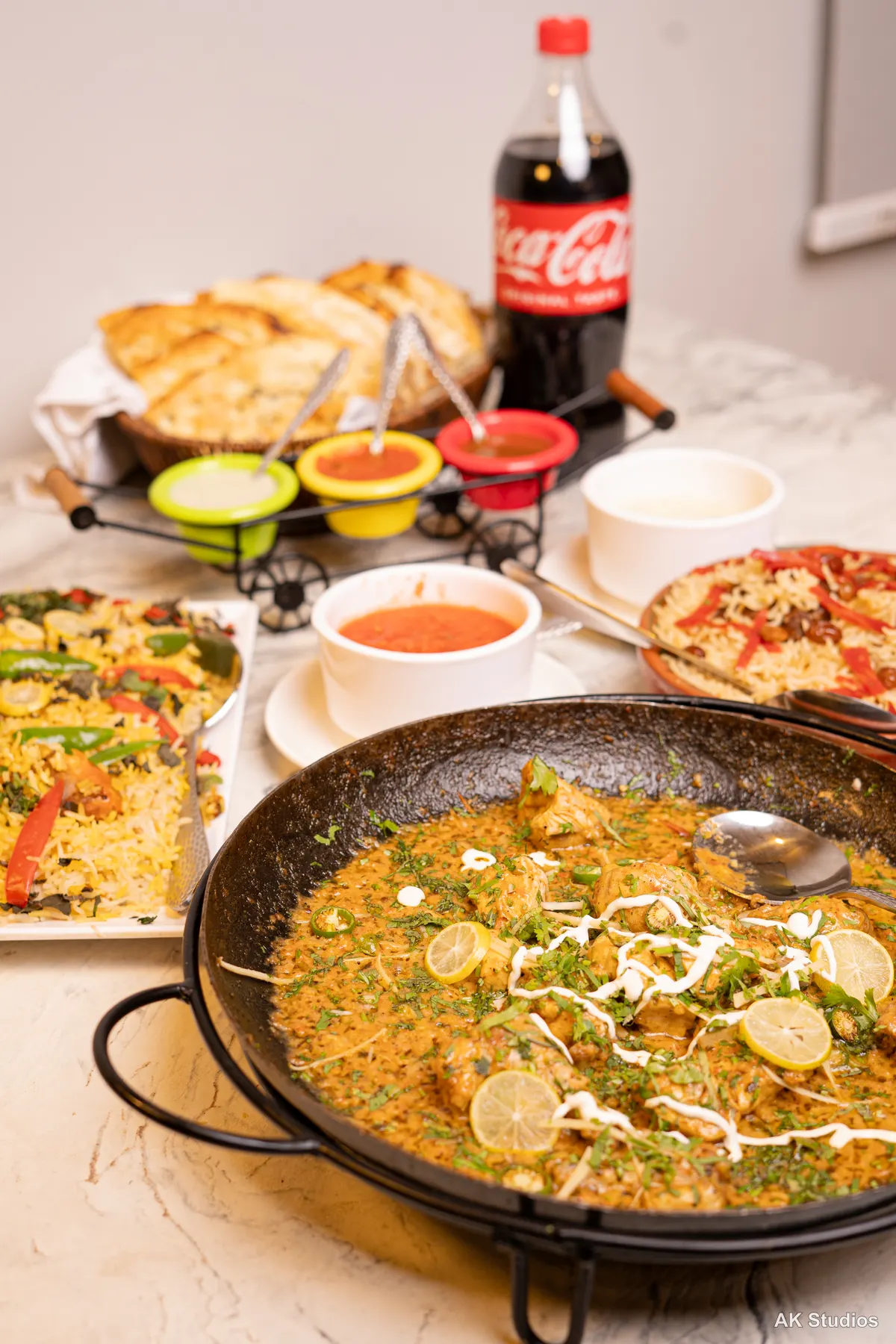 Saltish restaurant karahi, naan, biryani and soup table spread — food photography by AK Studios