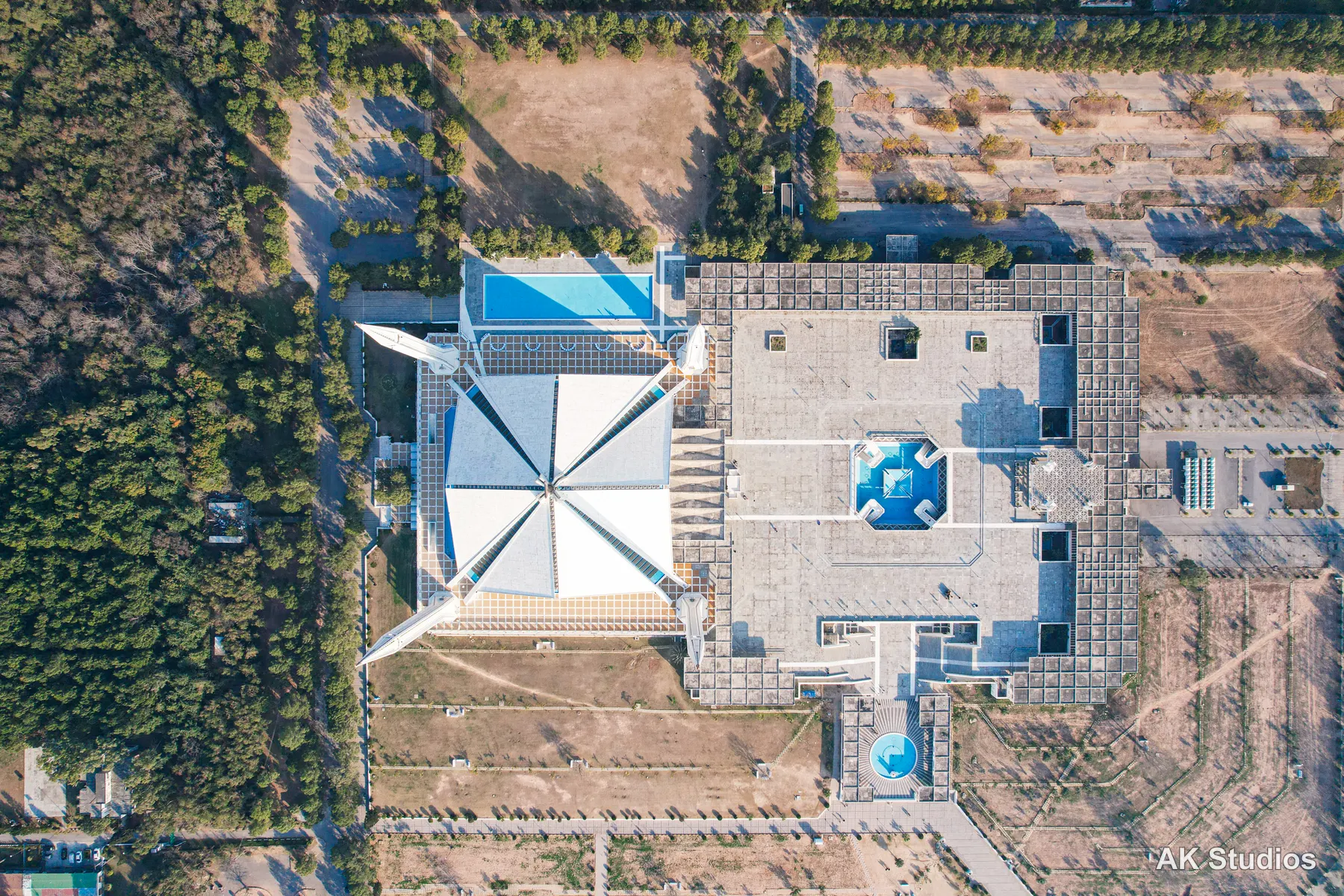 Aerial drone view directly overhead of Faisal Mosque in Islamabad, showing its distinctive triangular roof and courtyard