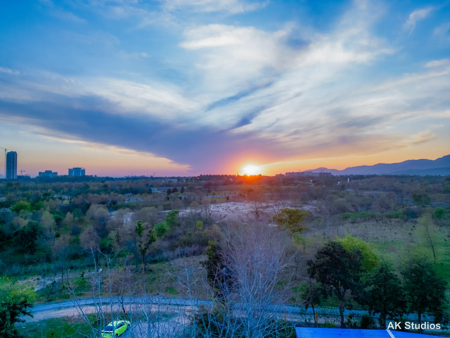 Aerial drone view of Islamabad's skyline at sunset with the Margalla Hills silhouetted in the background