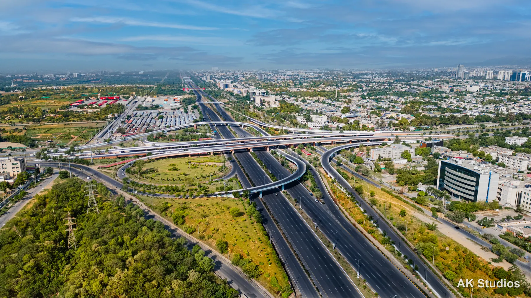 Aerial drone view of a major road interchange and commercial district in Islamabad with office buildings and greenery