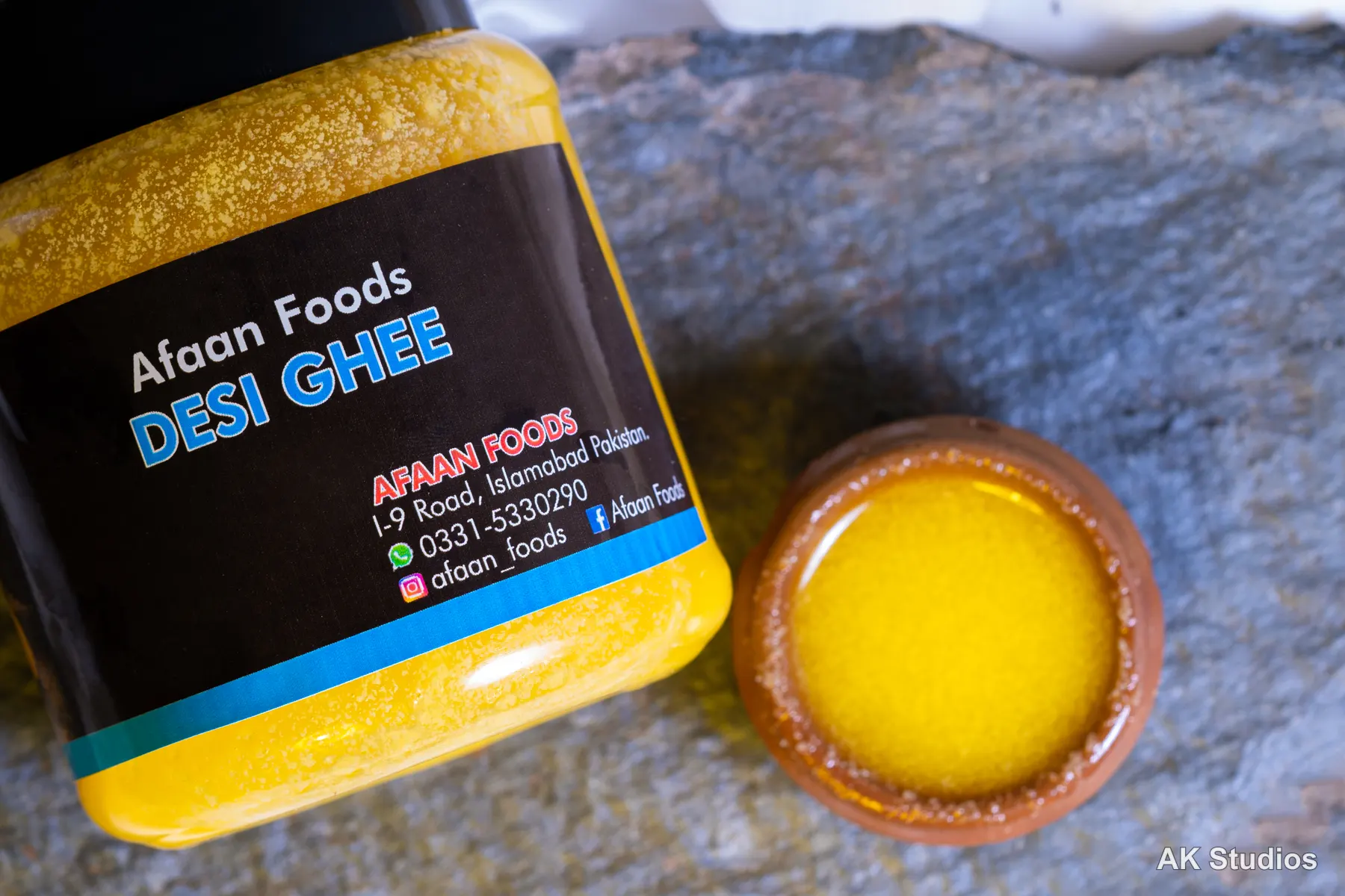 Afaan Foods desi ghee jar and clay pot styled on a stone surface — product photography by AK Studios